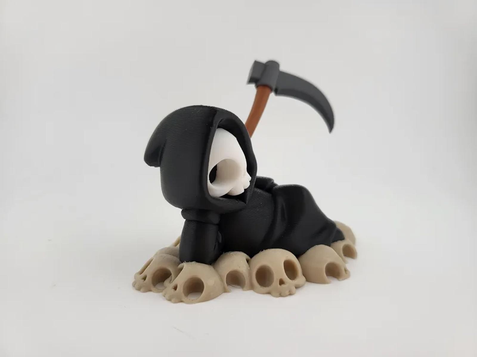 Chillin&rsquo; Grim Reaper Skeleton Figure on Skull Pile