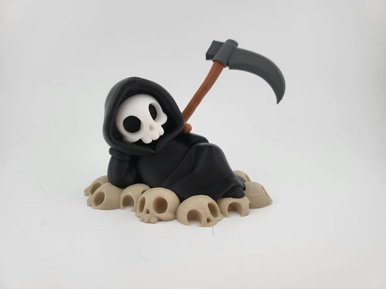 Chillin&rsquo; Grim Reaper Skeleton Figure on Skull Pile