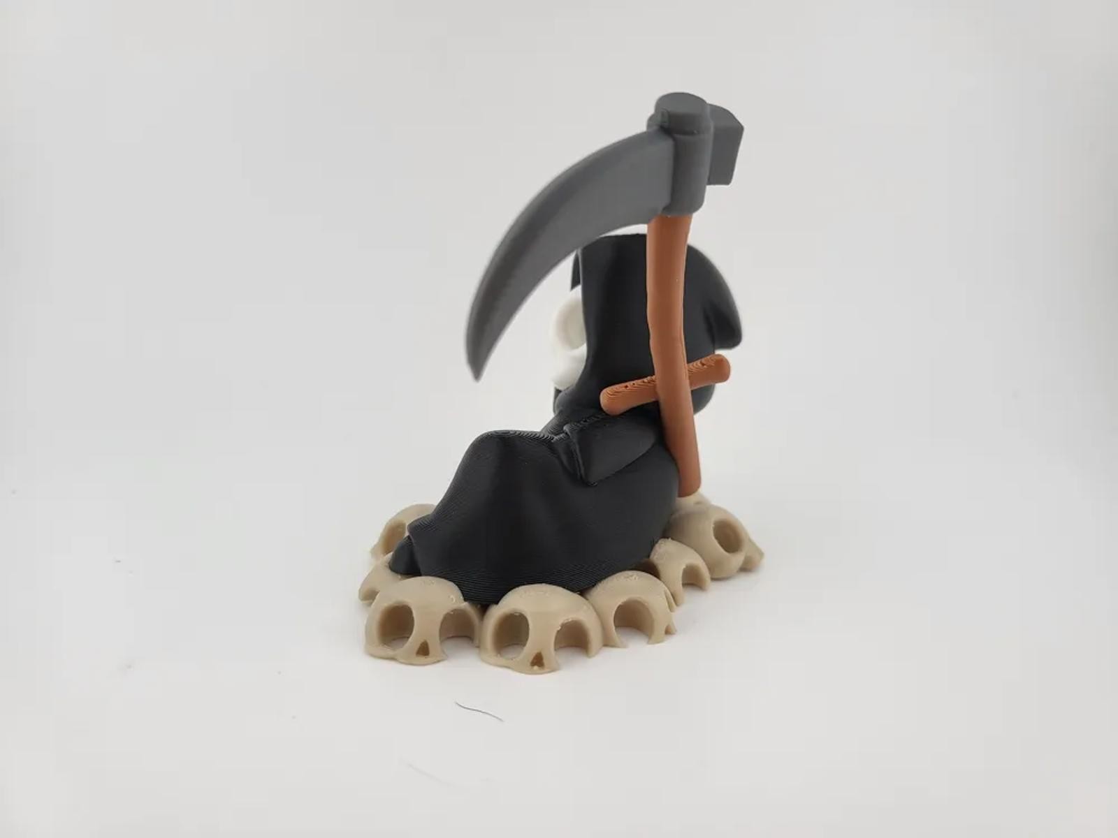 Chillin&rsquo; Grim Reaper Skeleton Figure on Skull Pile
