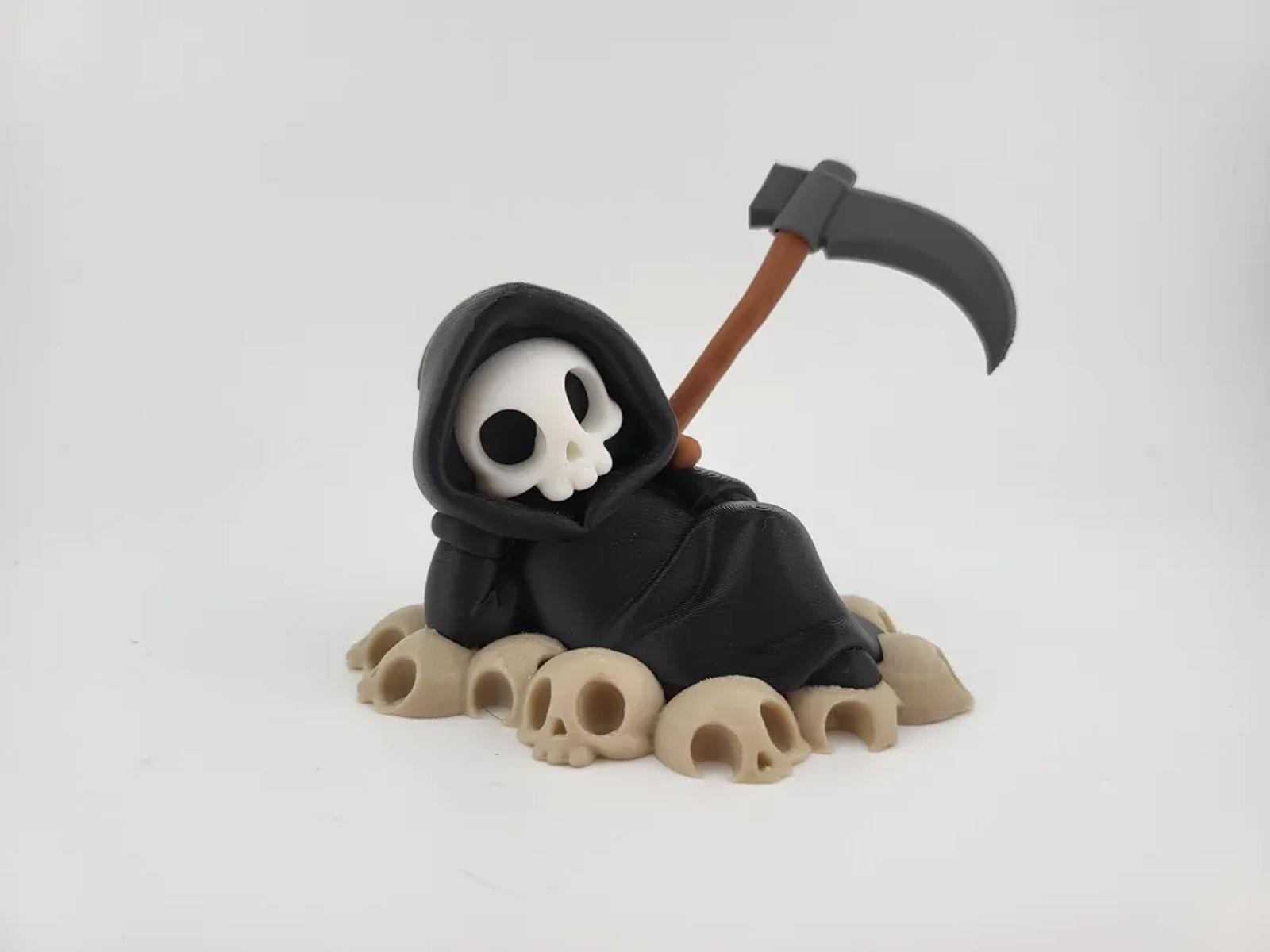 Chillin&rsquo; Grim Reaper Skeleton Figure on Skull Pile